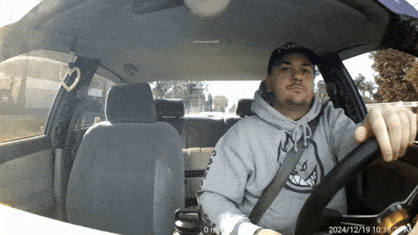 AI dashcam footage of a driver using a phone with a detection box flagging the violation, illustrating real-time in-cab coaching.