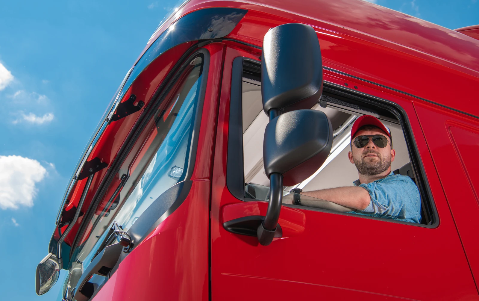 Commercial truck driver operating a fleet vehicle while GPS driver behavior monitoring helps improve road safety.