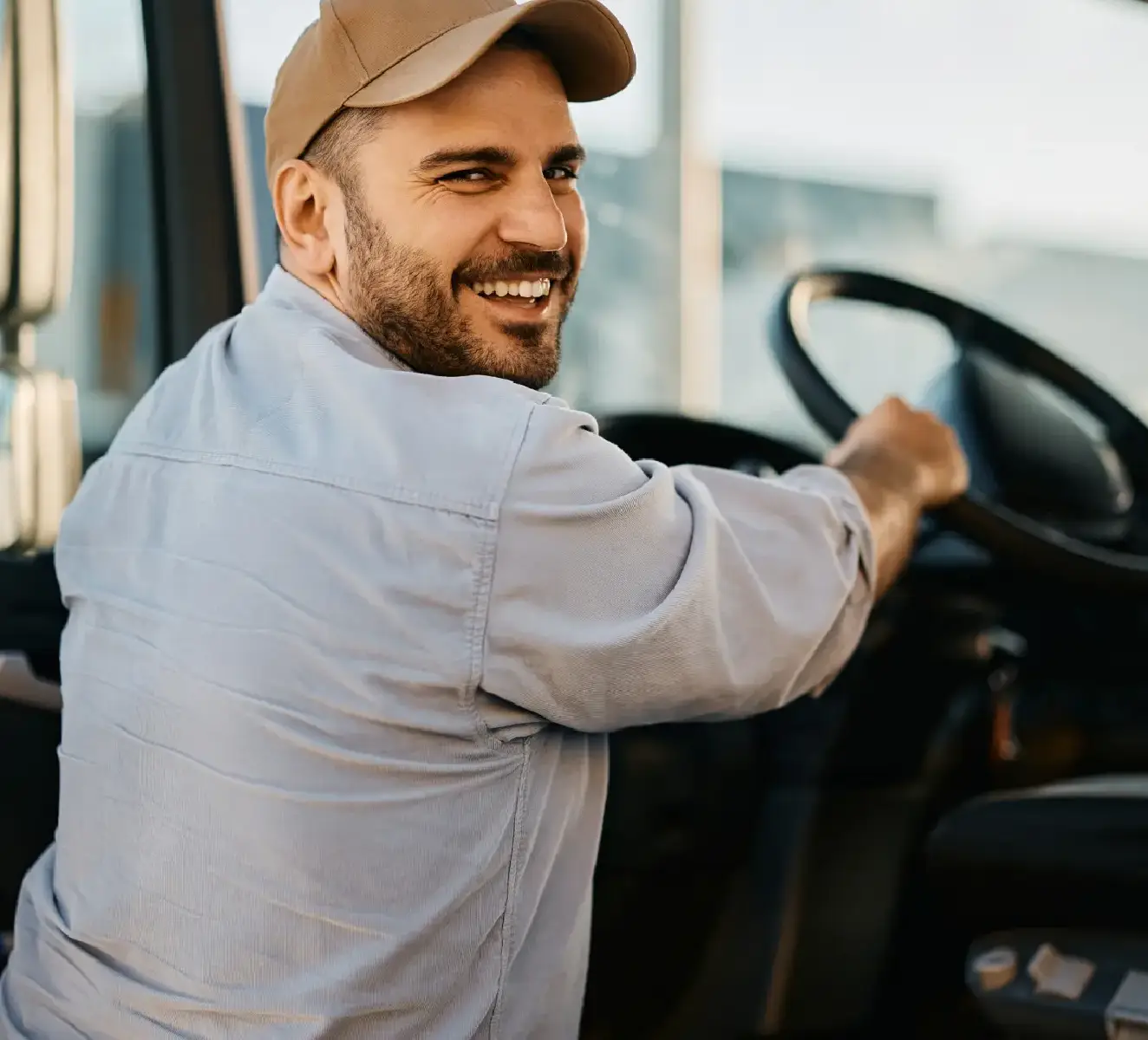 Happy trucker leaning on truck