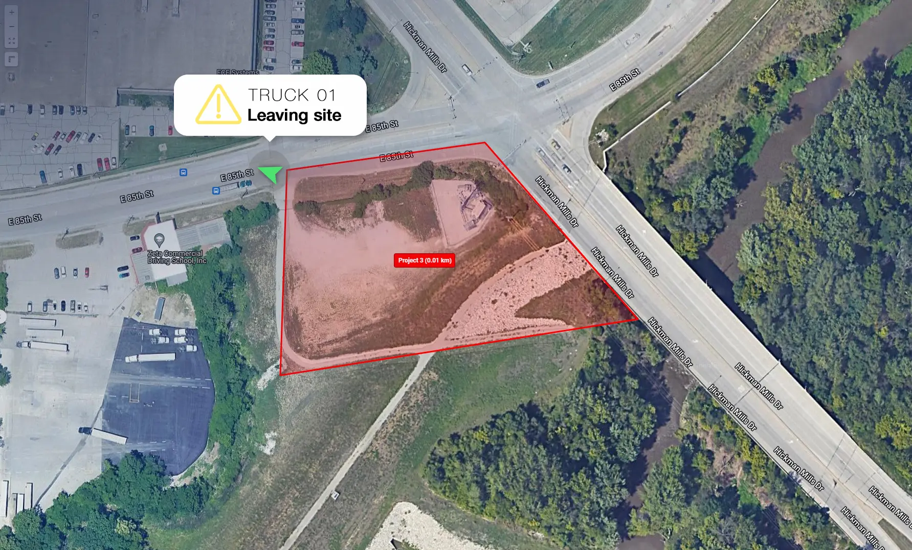 Satellite view of a construction jobsite geofence with an alert notification showing a truck leaving the designated zone