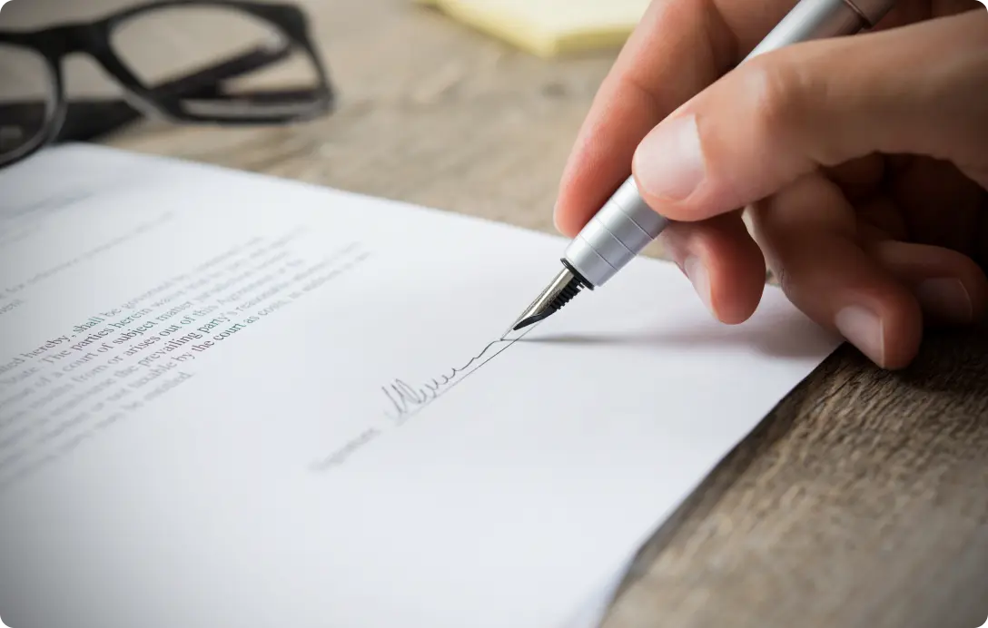 A small-business owner sitting across from a salesperson, signing a contract, conveying the drop in support quality that typically happens after signing that this section describes.