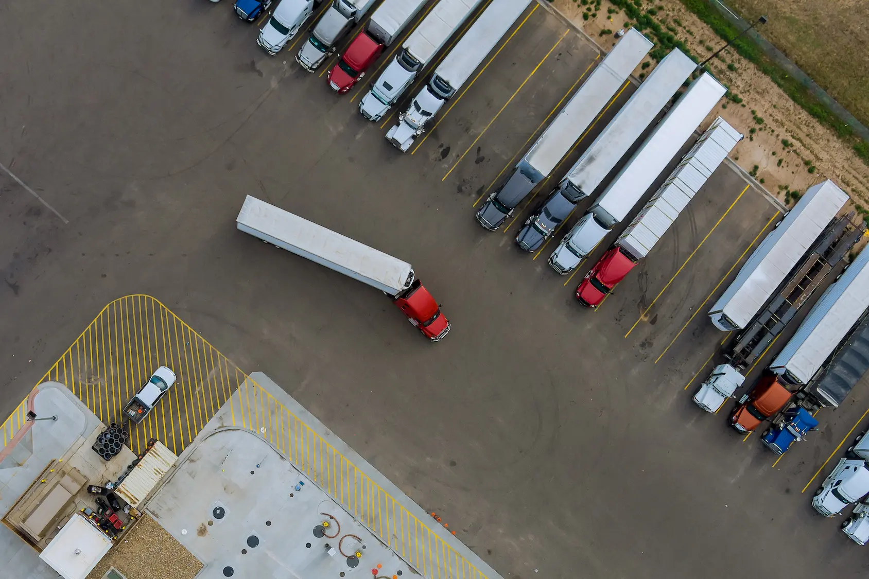 Aerial view of a fleet of trucks parked in a logistics yard
