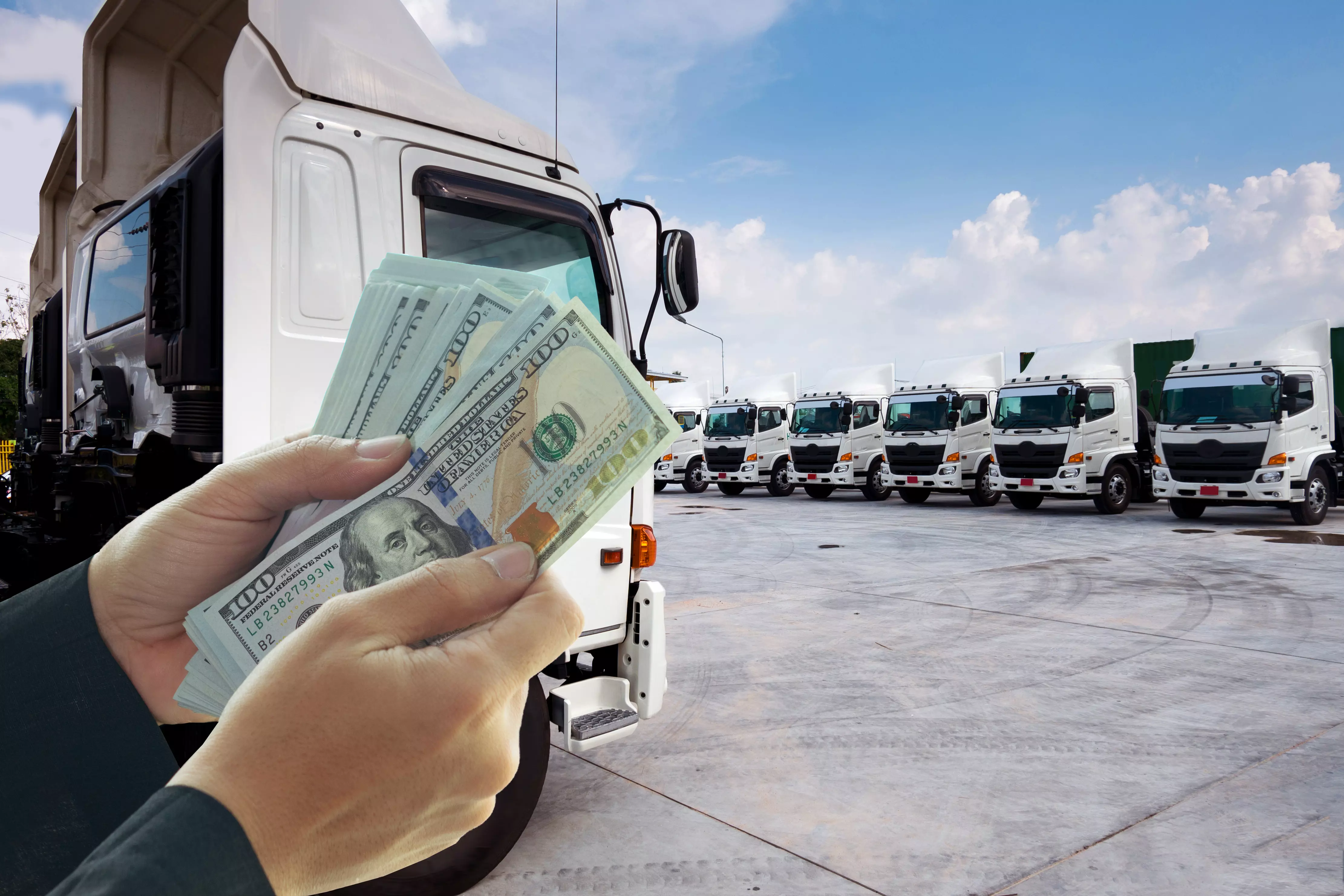 Counting money in front of trucks