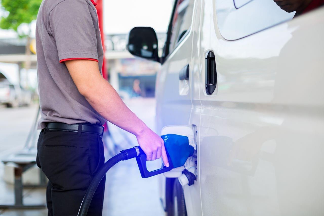 Someone fueling a van that has a gps tracker