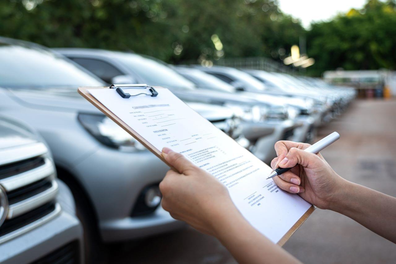 Clipboard in front of a fleet of cars