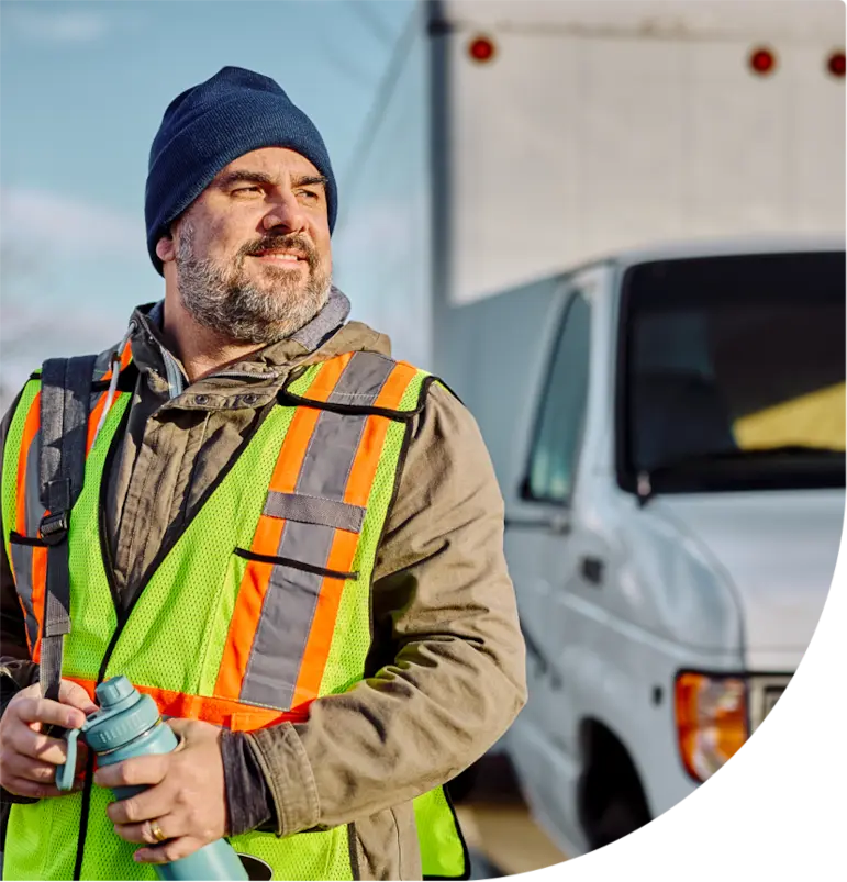 Driver holding water bottle in front of a vehicle