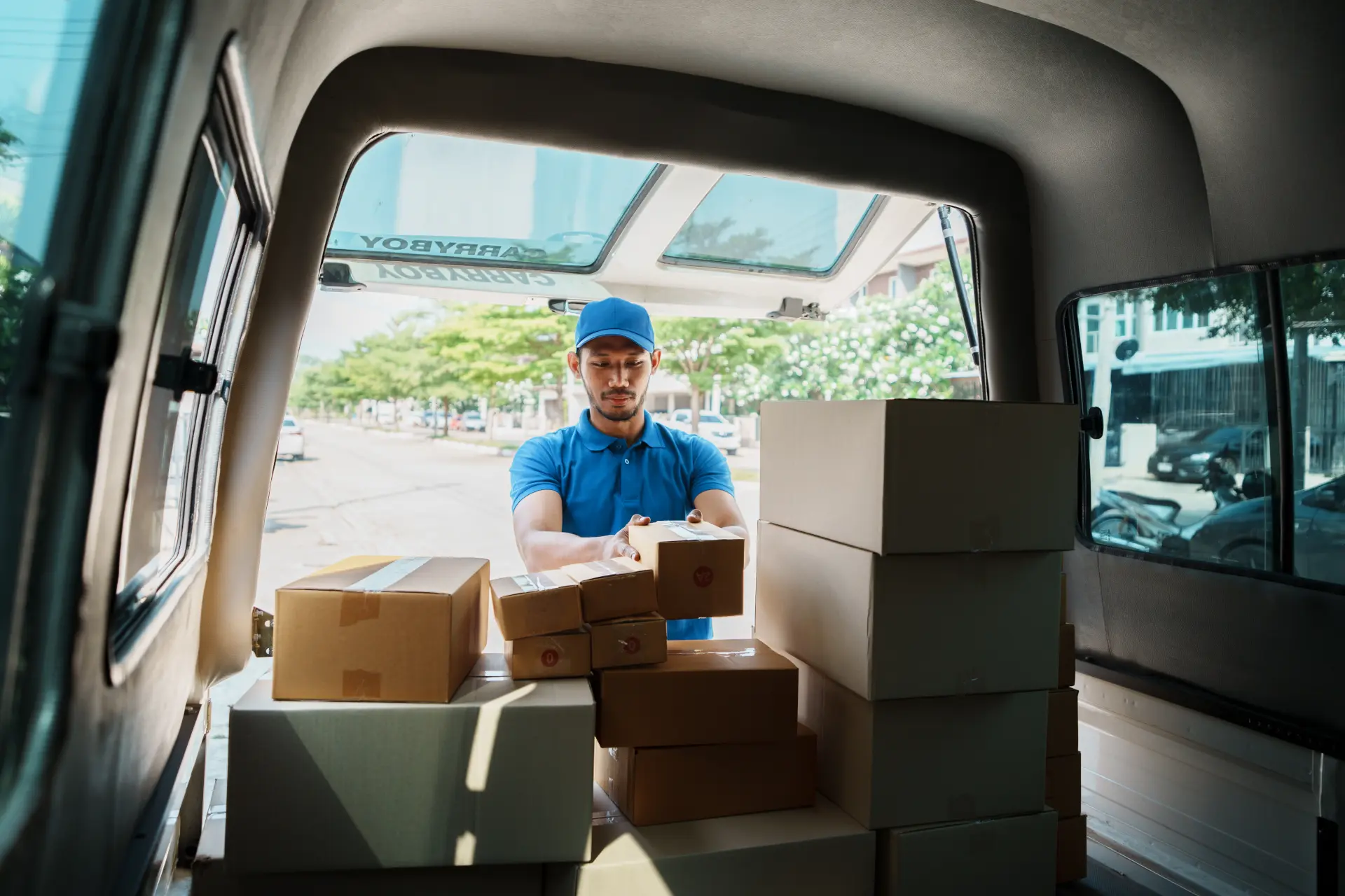Delivery person organizing parcels in a van