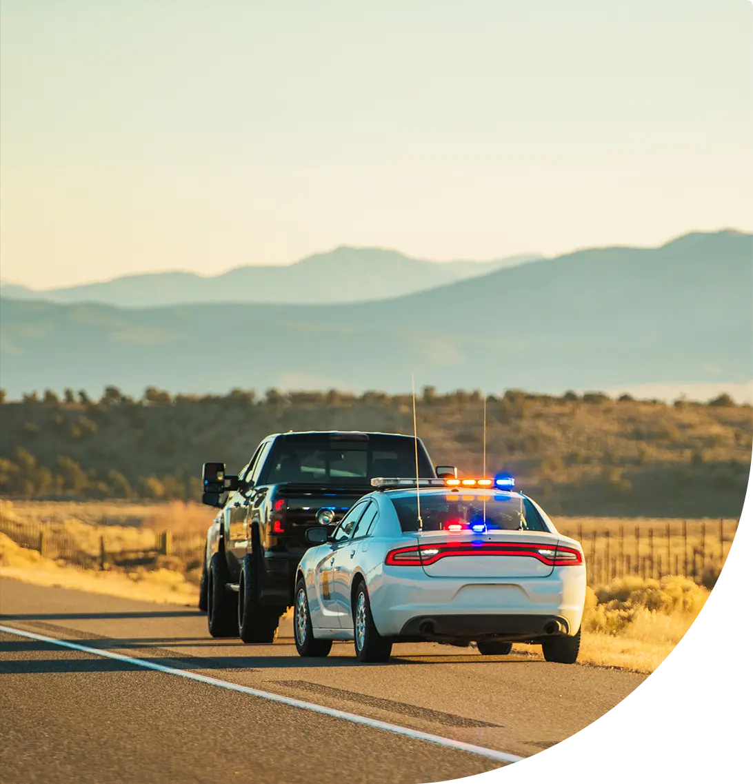 White police car pulling over a black pickup truck